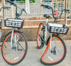Street bikes in the parking lot. One of the bicycles has a bent front wheel. Bicycle rental outdoors. Bike sharing in the city.